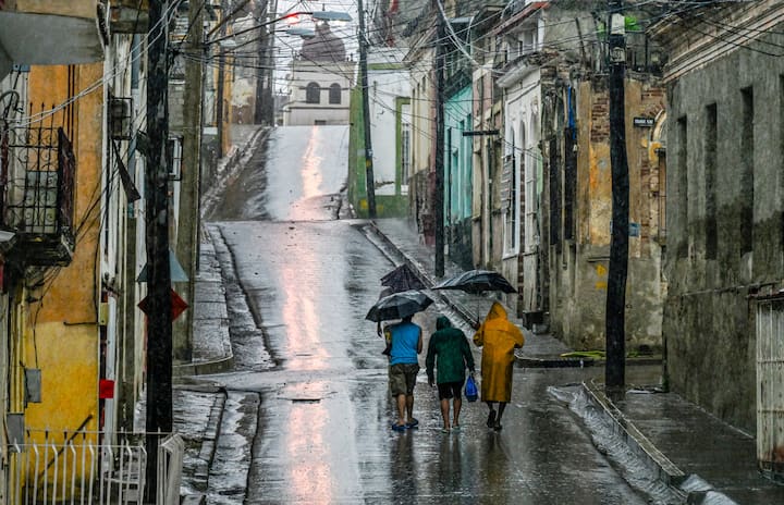 People walk in a street before Hurricane Melissa hits