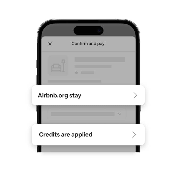 Grayed-out phone screen with Confirm and pay at the top. In the middle is a white box saying “Airbnb.org stay” next to a toggle. Below is a white box saying “Credits are applied.”