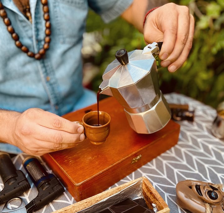 An image of someone pouring a small cup of Cuban coffee