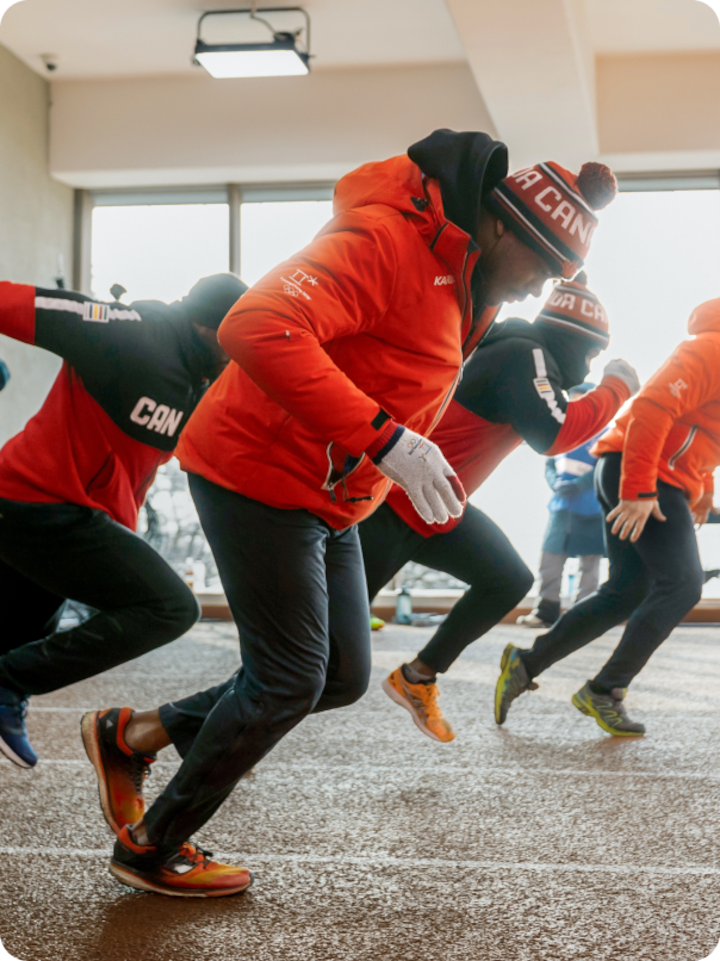 Wide shot of Neville Wright and the team Canada bobsled team training in a workout facility