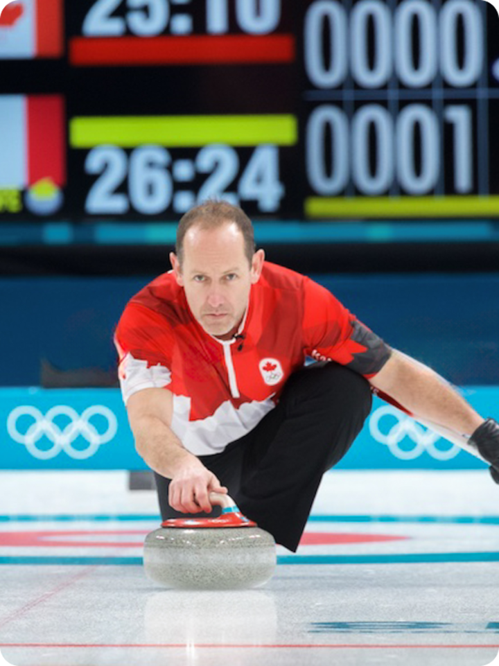 Brent Laing of team Canada crouches and sends a rock down the ice directly toward camera