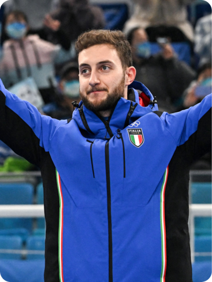 Italian Olympic curler Amos Mosaner raises his hands to the crowd