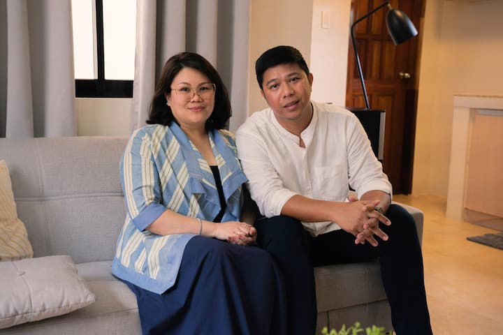 To verter sitter ved siden av hverandre på sofaen og smiler til kameraet.