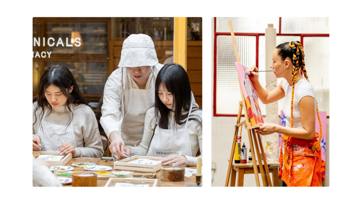 Des personnes assises à une table participent à un atelier pratique et peignent des carreaux de céramique, tandis qu'une autre personne est debout et peint sur une toile dans un studio lumineux.