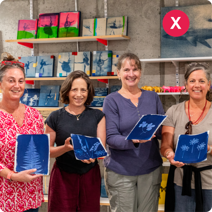 Des participants à un atelier artistique présentent des plans de motifs floraux et végétaux, avec des étagères d'œuvres d'art terminées visibles en arrière-plan.