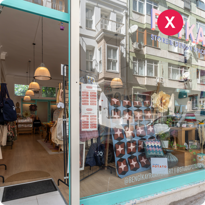 La devanture d'une boutique de design présentant des couettes et des articles artisanaux, avec le reflet des bâtiments voisins dans la vitrine.