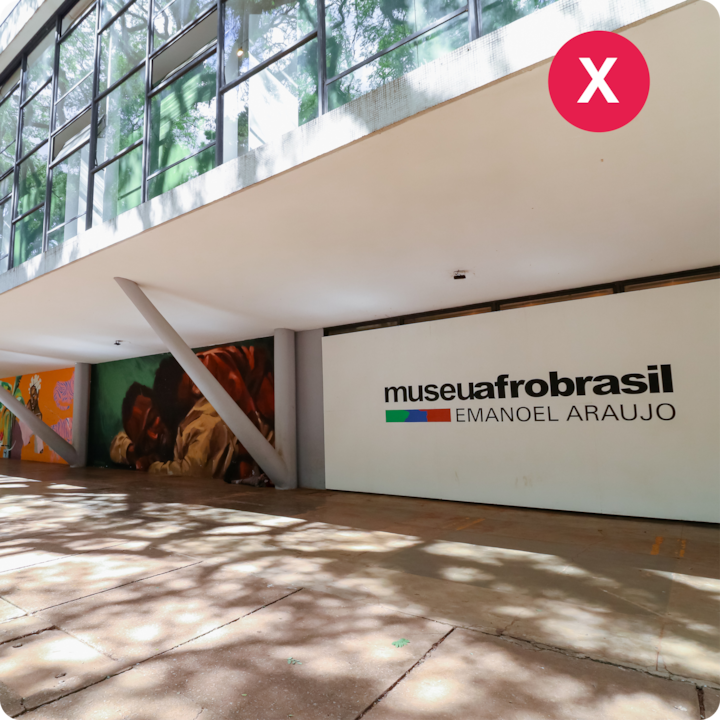 Vue extérieure du Museu Afro Brasil Emanoel Araujo, avec une architecture moderne et des peintures murales colorées sous des arbres ombragés.