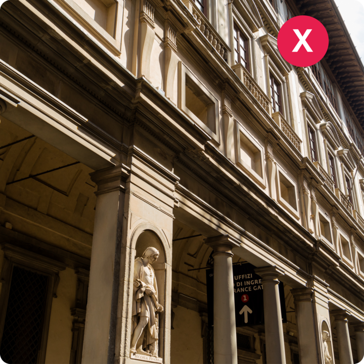 L'architecture de style Renaissance de la galerie des Offices à Florence, avec une statue dans une alcôve et un panneau indiquant l'entrée.