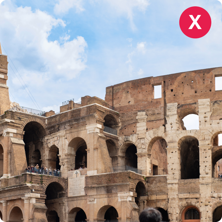 Vue du Colisée emblématique de Rome, en Italie, mettant en valeur ses arches anciennes et ses murs partiellement en ruines sous un ciel dégagé.
