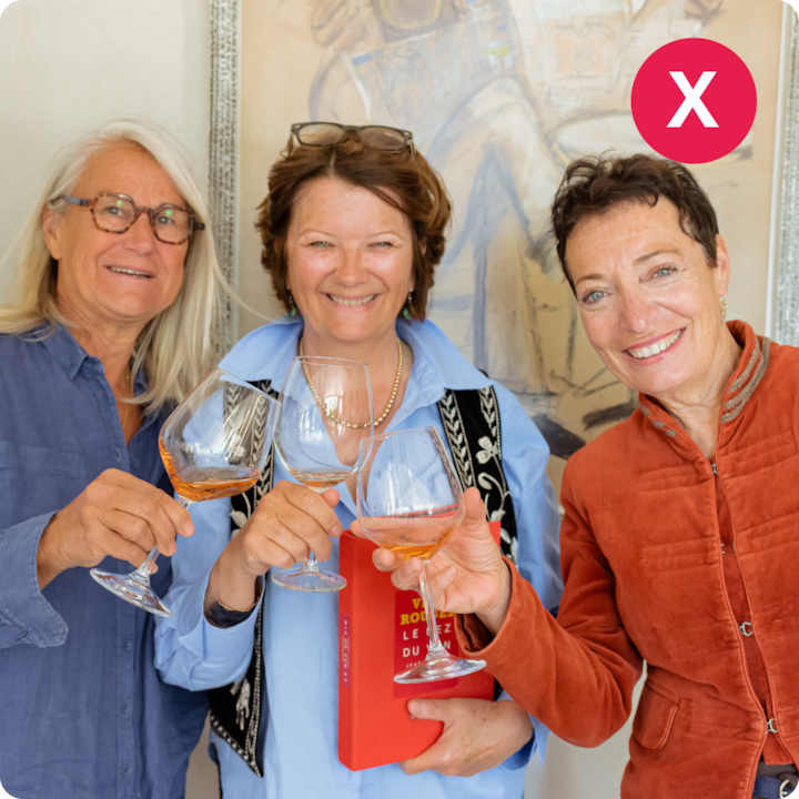 Trois personnes tiennent des verres de vin dans une ambiance décontractée évoquant une expérience de dégustation. L'une d'entre elles tient aussi un livre.