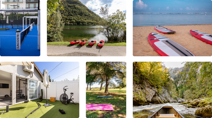 Quatre kayaks rouges sont disposés sur l'herbe d'une rive, avec autour des collines verdoyantes sous un ciel ensoleillé.