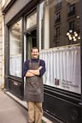 Erwan standing in front of wine shop with arms folded