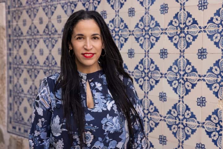 Ruthy standing outside in front of a blue and white tiled wall