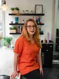 Debora wearing an orange shirt sitting