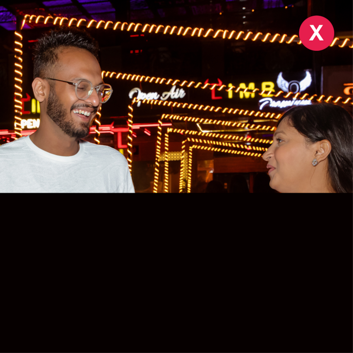 Une scène de nuit avec des enseignes et des guirlandes lumineuses, illustrant des conditions d'éclairage difficiles.