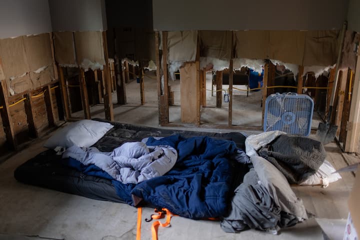 Et hjem med vannskader og en sovepose på gulvet etter at det kom vann inn i hjemmet på grunn av en oversvømmelse.