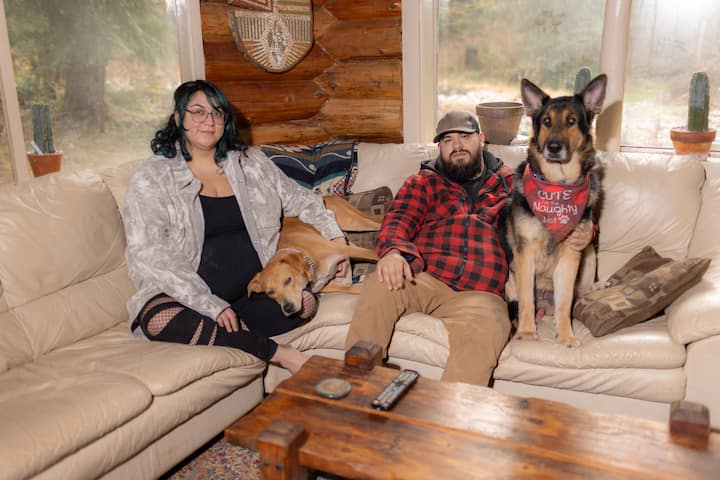 Et familiebilde av en kvinne, Tawnessa, og partneren hennes, Brian, med hundene Frida og Kaiser.