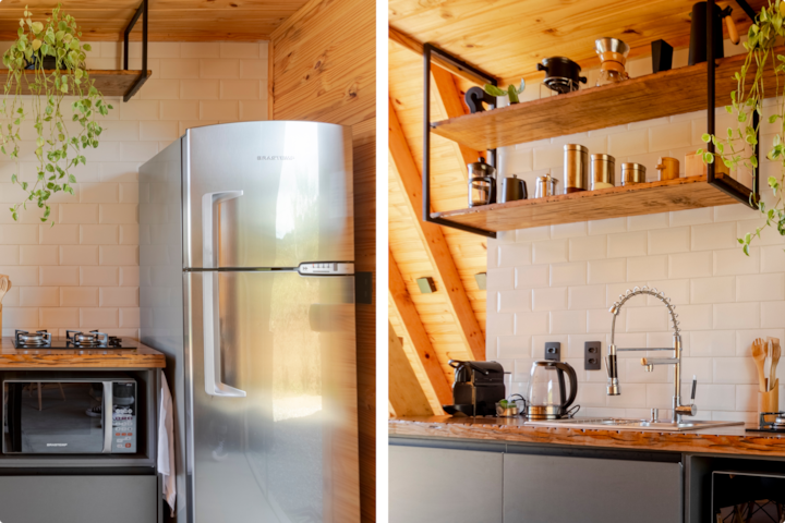 Cuisine minimaliste dans un logement de style cabane avec un réfrigérateur, une cuisinière, un four à micro-ondes et un évier. Des étagères en bois sont garnies d'ustensiles de cuisine, et des plantes retombantes ajoutent une touche naturelle.