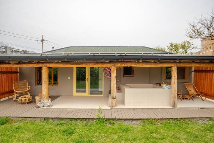 Un petit espace extérieur avec une terrasse au style rustique, des meubles en bois et des portes jaunes, associant touches naturelles et éléments modernes.