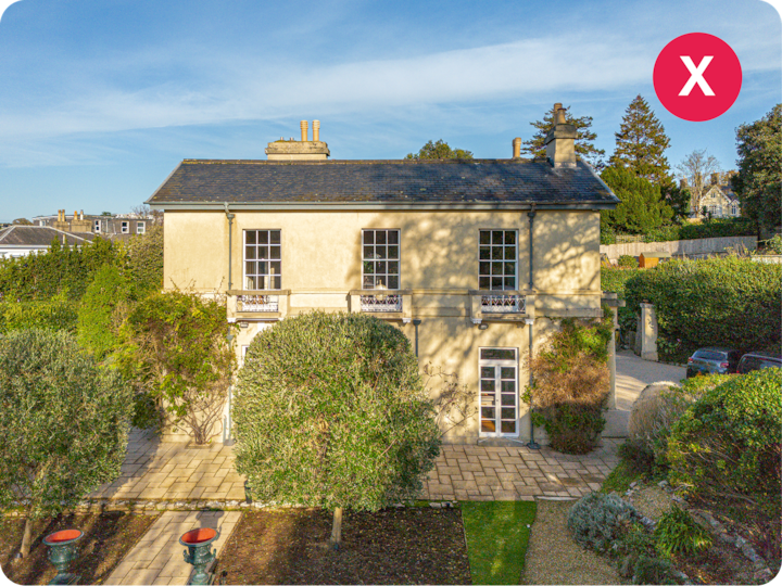 Vue aérienne d'un logement de style villa avec un toit en ardoise. Il est entouré d'un jardin et d'une allée en pavés de pierre.