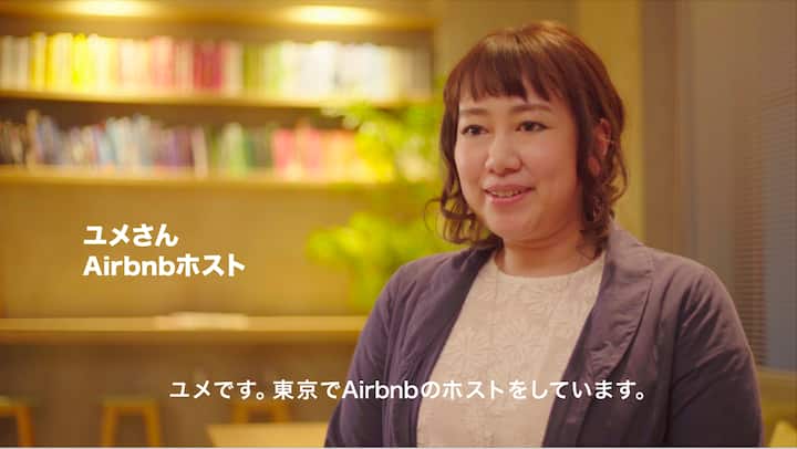A person standing indoors with a bookshelf in the background, overlaid text reads 'Yume-san, Airbnb Host' in Japanese, with additional text introducing the host's role in Tokyo.