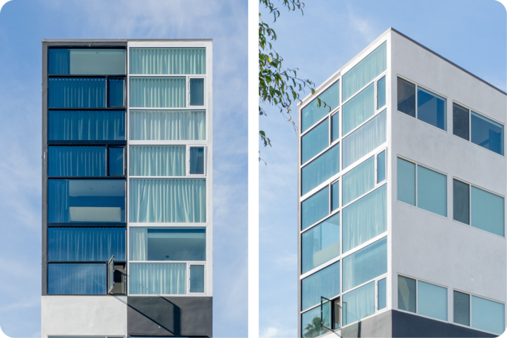 Deux façades d'hôtel modernes et géométriques, avec de grandes baies vitrées à l'encadrement blanc épuré, sous un ciel bleu sans nuages.