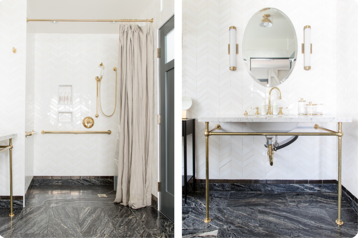 Une salle de bain élégante avec douche aux détails dorés équipée de barres d'appui et un lavabo en marbre aux finitions également dorées. Mise en valeur par un carrelage blanc à chevrons et un sol en pierre foncée polie, la pièce allie accessibilité et sophistication.