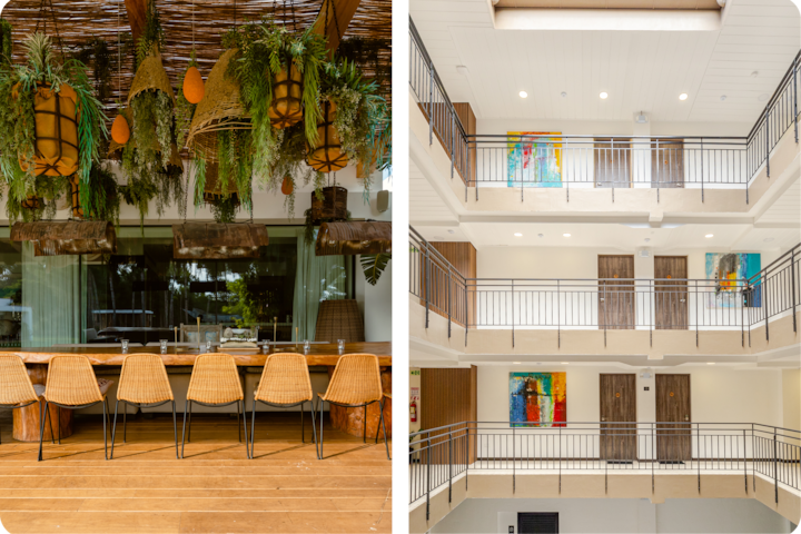 Un espace accueillant avec une table à manger rustique sous des plantes et un éclairage chaleureux, à côté d'un atrium d'hôtel moderne aux murs blancs, avec des éléments en bois et des tableaux colorés.