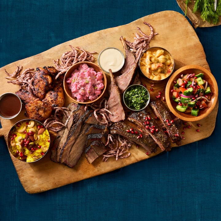 Un plateau de mets magnifiquement présenté, avec des viandes grillées, des salades colorées, des sauces et des accompagnements, mettant en valeur un style culinaire créatif pour des programmes de photographie.