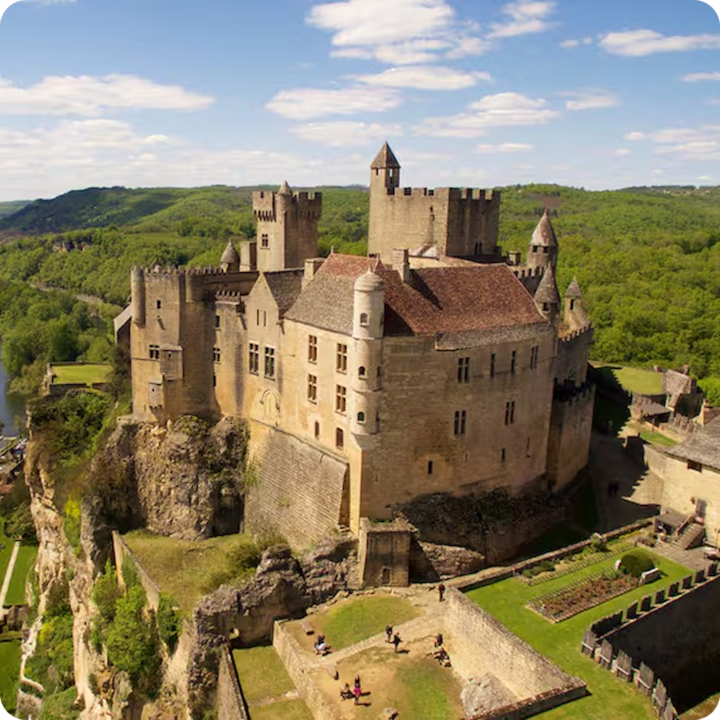 Un grand château médiéval avec plusieurs tours, perché sur un promontoire rocheux.