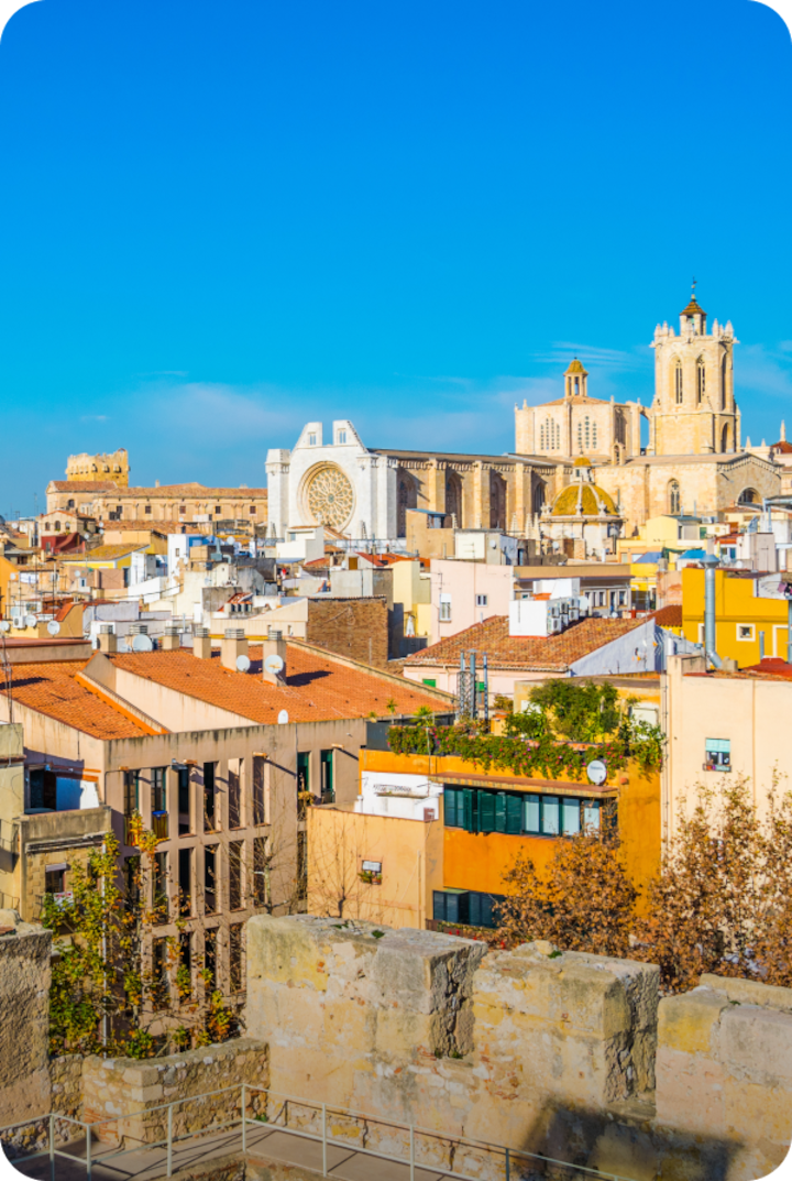 Vue de la ville de Tarragone sous un ciel bleu éclatant. Texte superposé : « Étape 2 – Tarragone », avec une flèche vers la droite.