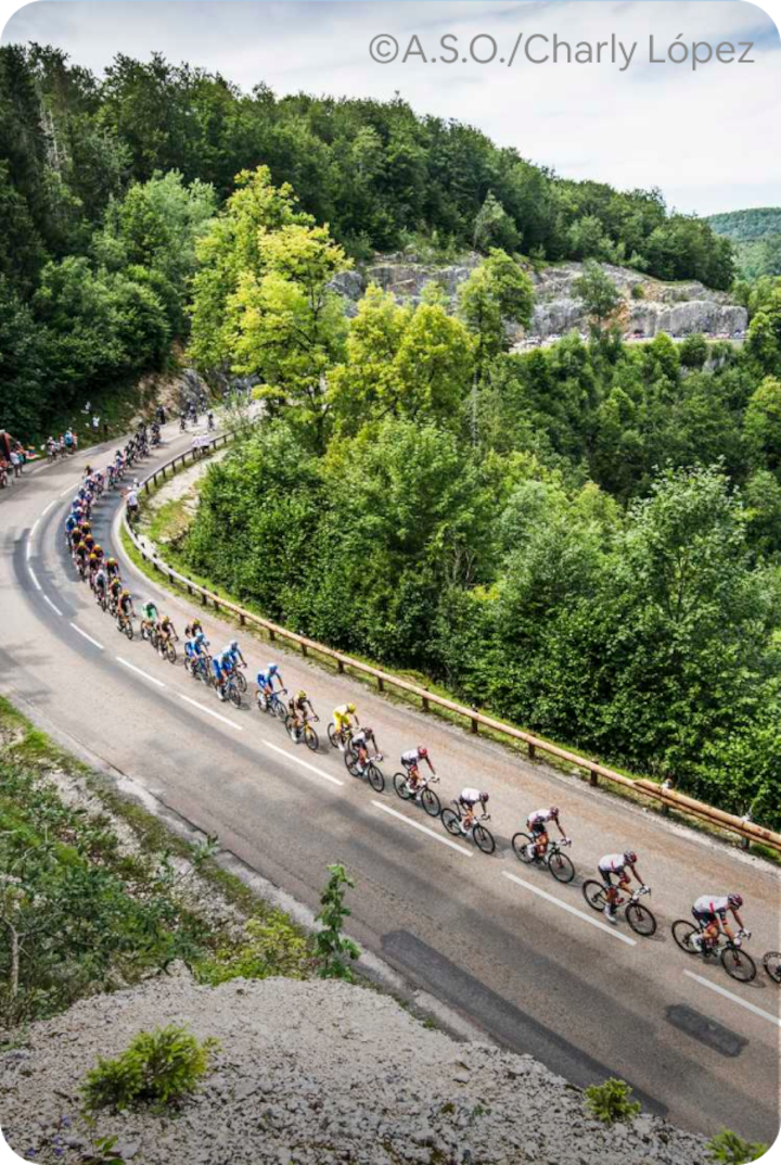Des cyclistes professionnels roulent sur une route sinueuse à travers une forêt verdoyante. Texte superposé : « Étape 4 – Carcassonne », avec une flèche vers la droite.