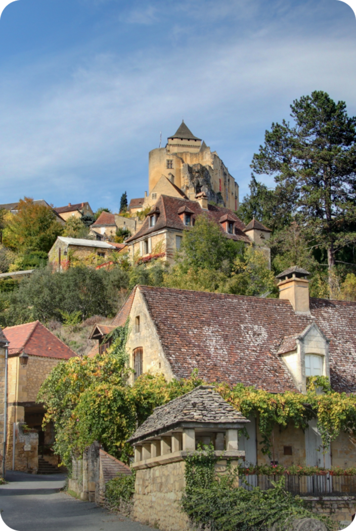 Un village pittoresque avec des maisons en pierre à flanc de colline, traversé par une route étroite. Texte superposé : « Étape 8 – Périgueux », avec une flèche vers la droite.
