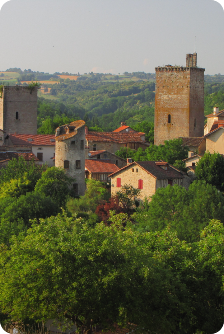 Un village français avec des maisons en pierre et toits en tuiles rouges, entouré d'une végétation verdoyante. Texte superposé : « Étape 10 – Aurillac », avec une flèche vers la droite.