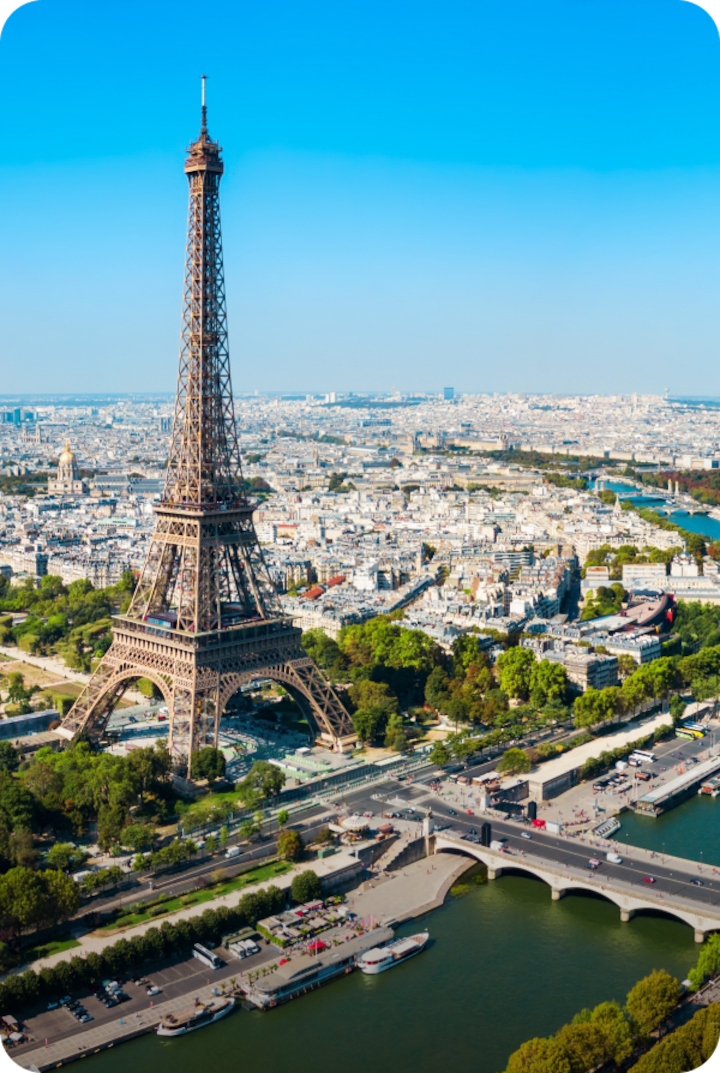 Vue aérienne de la tour Eiffel, avec la Seine qui serpente à ses pieds. Texte superposé : « Arrivée à Paris », avec une flèche vers la droite.