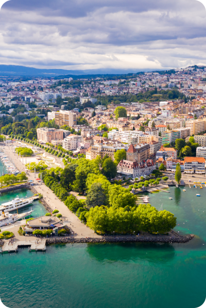 Vue aérienne des rives de Lausanne. Texte superposé : « Étape 1 – Lausanne », avec une flèche vers la droite.