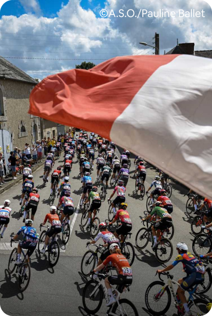 Des cyclistes professionnels traversent Mâcon sous les acclamations de la foule, avec un drapeau français au premier plan. Texte superposé : « Étape 5 – Mâcon », avec une flèche vers la droite.