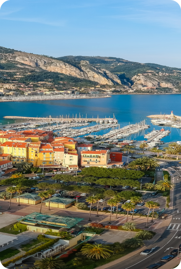 Vidéo aérienne de Nice, entre ville et marina. Texte superposé : « Étape 9 – Nice », avec une flèche vers la droite.