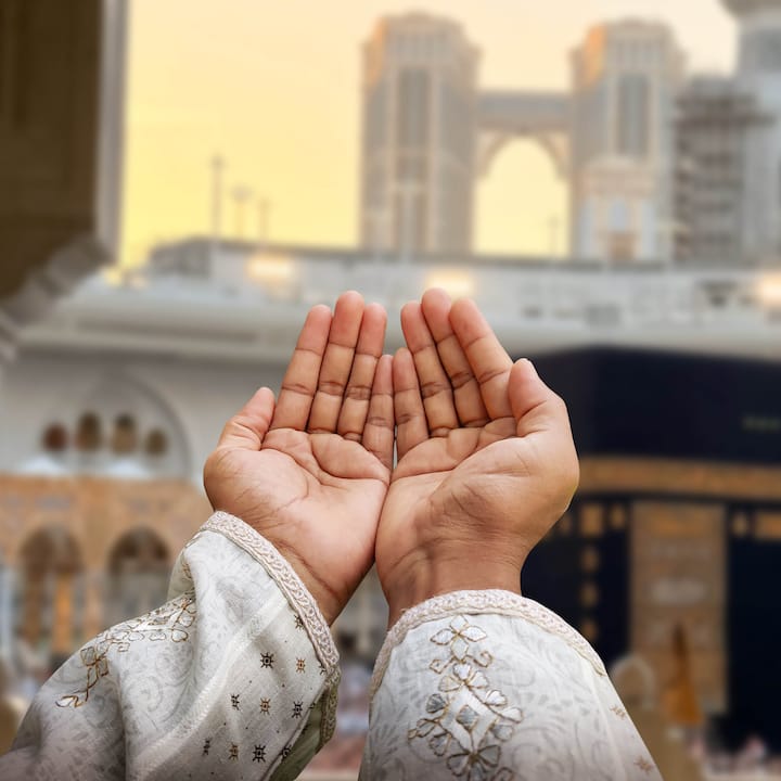 Hands reaching in prayer towards Masjid al-Haram in Mecca