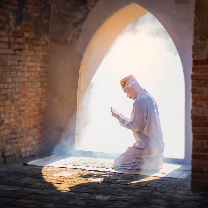 Man kneeling in prayer in old mosque