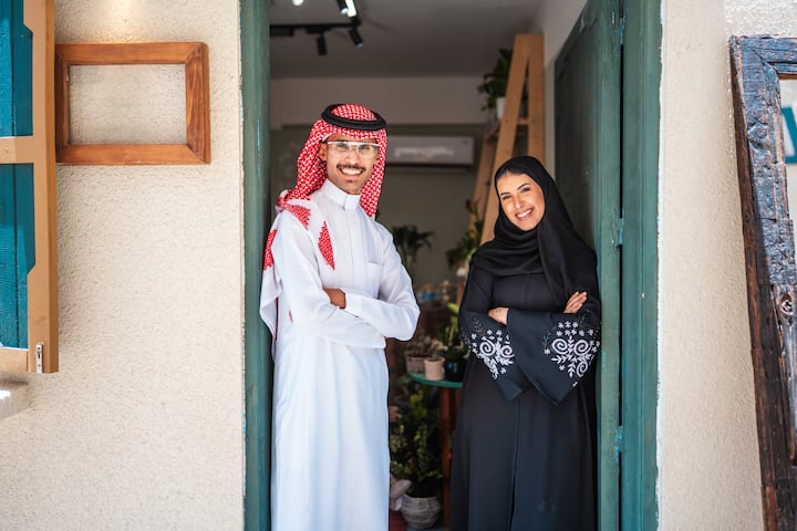 Arabic couple standing in doorway of shop in Saudi Arabia