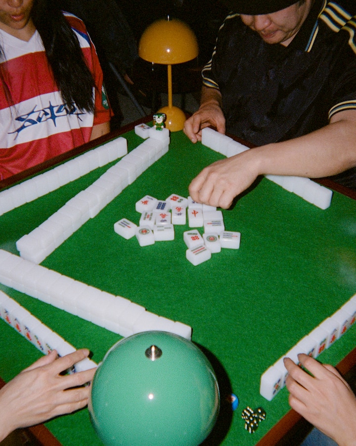 Four people play a game of mahjong