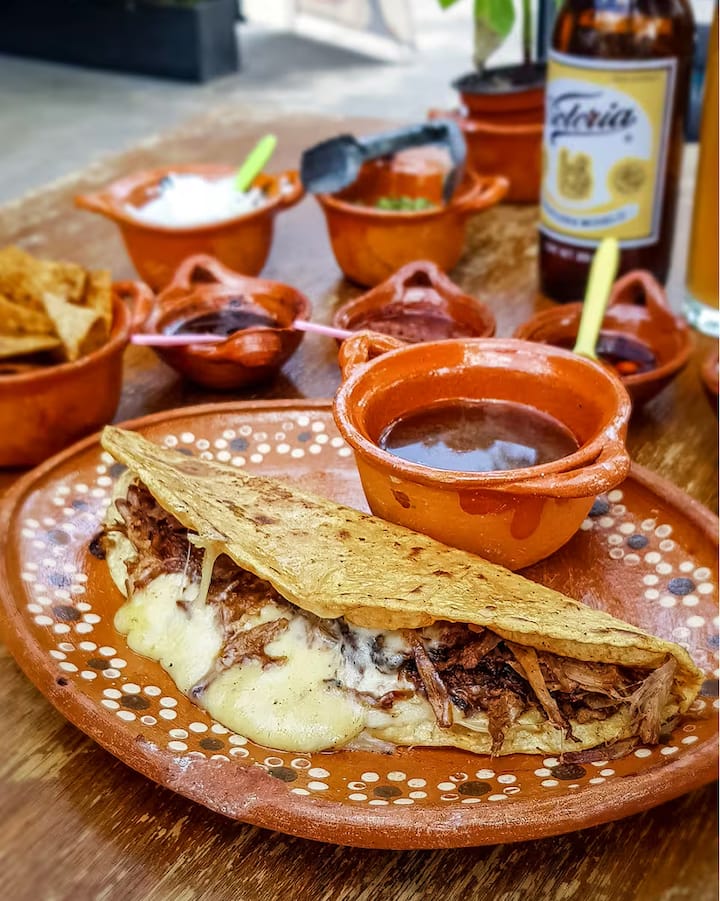 A close up of a quesabirria taco on a nicely staged table