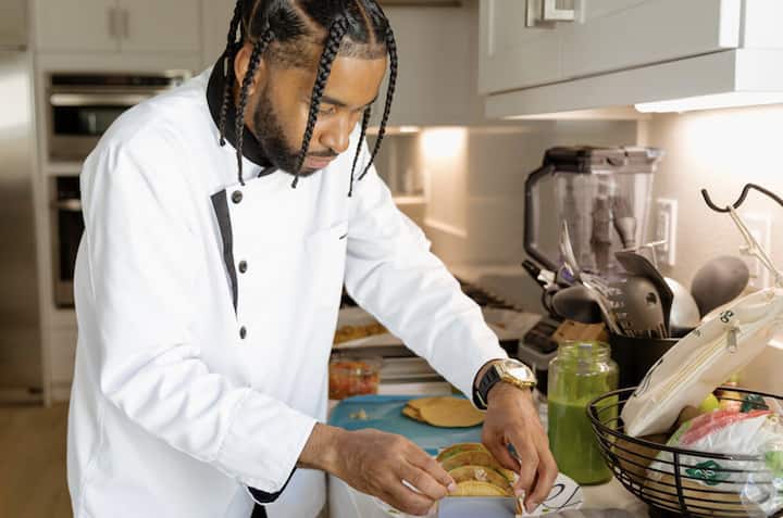 Services chef cooking tacos for soccer fan travelers.