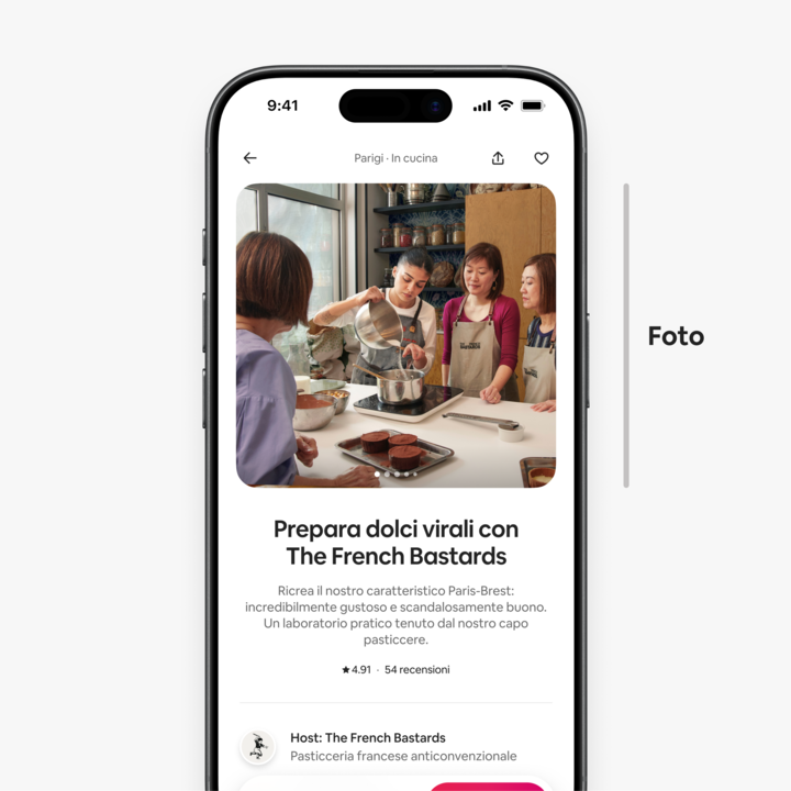 Annuncio di un'esperienza sullo schermo di un dispositivo mobile, che mostra ospiti riuniti attorno al bancone di una cucina intenti a preparare dolci.