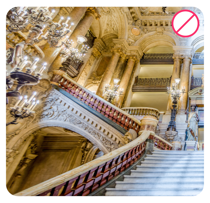 Ornate palace staircase with a red “no” symbol, illustrating an example of what to avoid in experience photos.