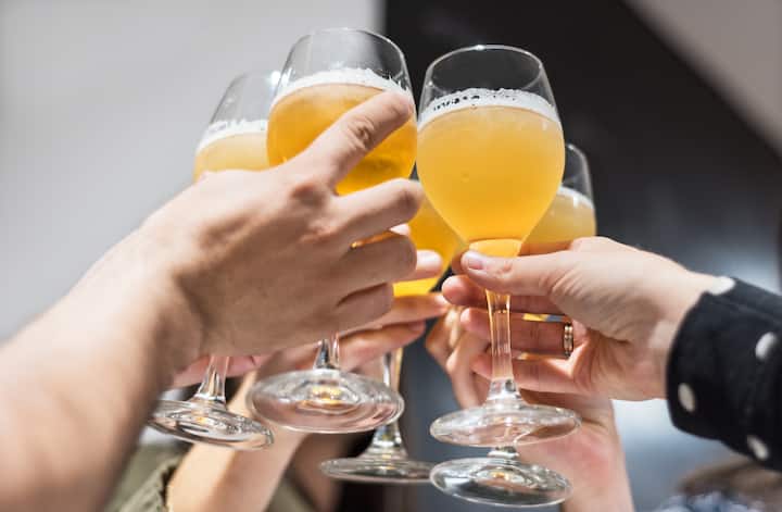 Amigos brindando con cervezas para celebrar juntos un día de partido.