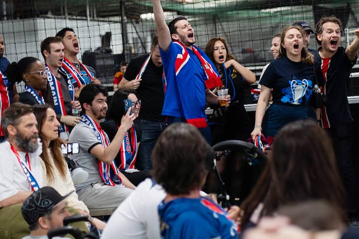 Des personnes portant des maillots d'équipe et des écharpes de la FIFA sont réunies à New York pour une expérience de match festive.