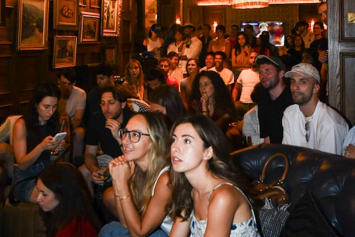 Dans un bar new-yorkais à l'ambiance tamisée, des supporters se pressent épaule contre épaule pour regarder un match de la FIFA.