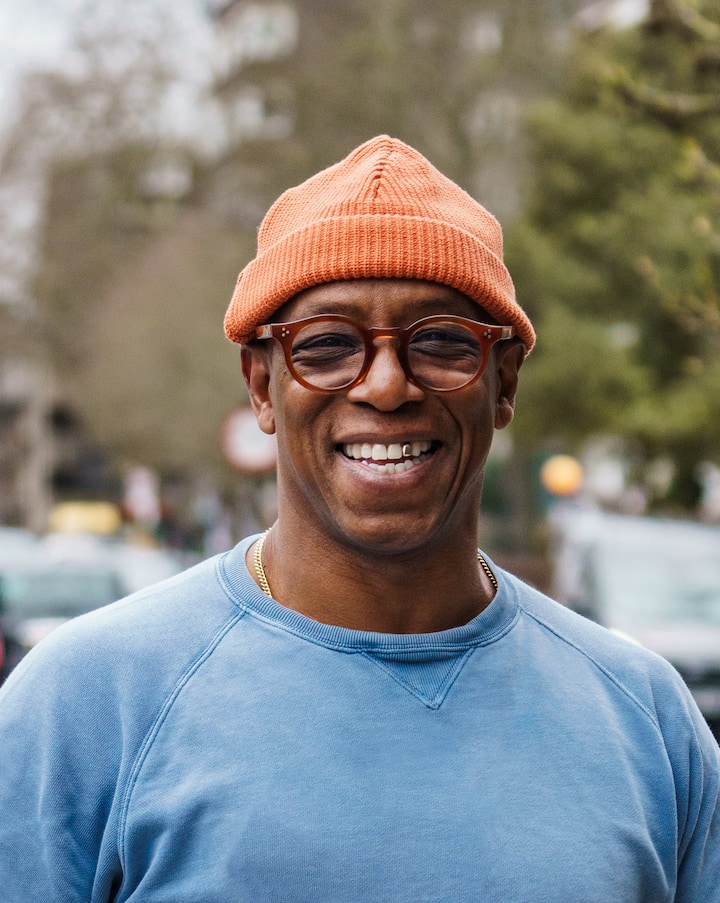 Une personne portant un bonnet orange en maille et un sweat-shirt bleu dans une rue de New York